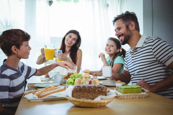 Famiglia felice che fa colazione insieme a tavola.